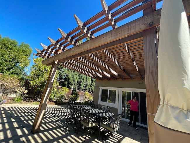 Weathered wood pergola before restoration in Redwood City, California showing faded wood and UV weathering
