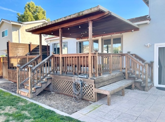 Weathered redwood deck before refinishing in San Jose, California showing faded gray wood and UV weathering
