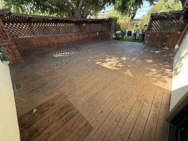 Weathered redwood deck before refinishing at a home in Santa Clara with faded boards and worn protective finish.