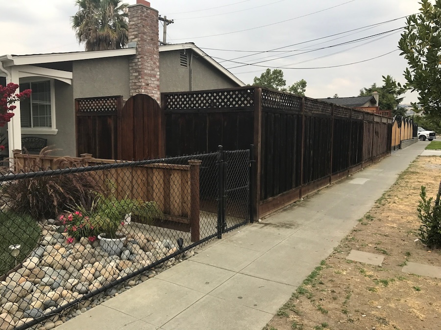 Weathered redwood fence before restoration in San Jose, California showing faded wood and UV weathering