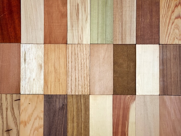 Various exterior wood species including redwood, cedar, and hardwood samples used for deck refinishing