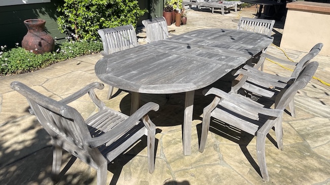 Weathered gray teak dining table and chairs before refinishing in Palo Alto