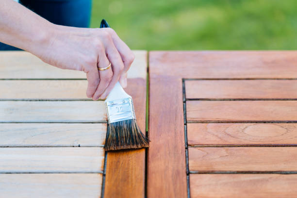 Applying oil to outdoor teak furniture during professional refinishing