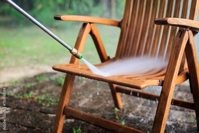 Outdoor teak furniture being professionally cleaned and refinished to restore natural color