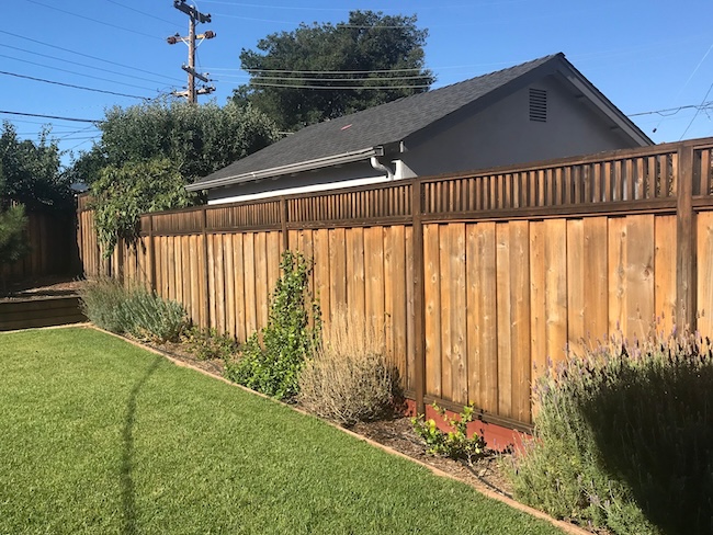 Weathered redwood backyard fence in San Jose before professional cleaning and staining